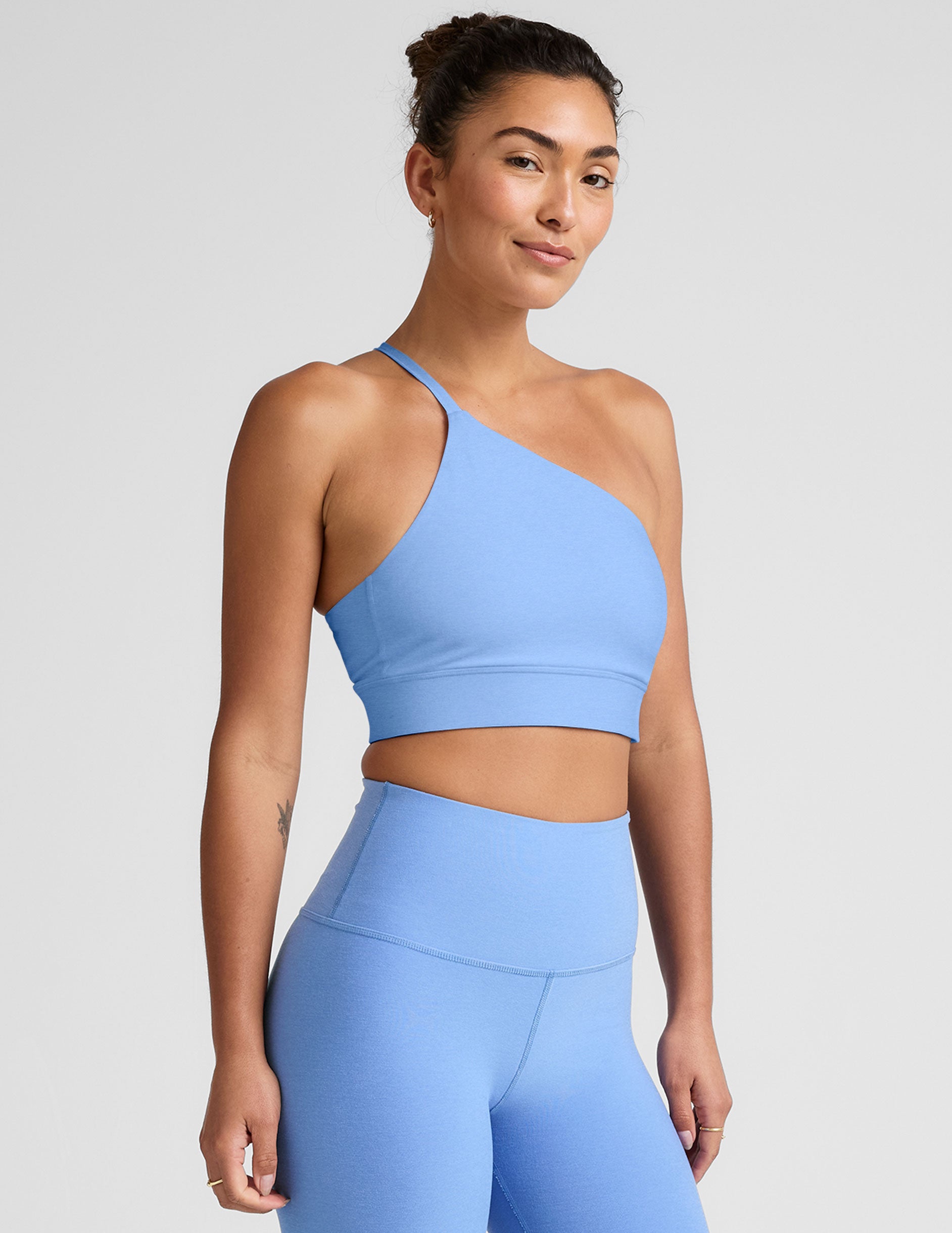 blue long line length bra with a one strap detail and an open back.