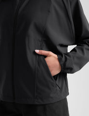model wearing a black jacket and shorts on a light gray background.