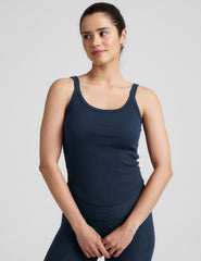 model is wearing a navy blue scoop neck ribbed tank top against a plain background.