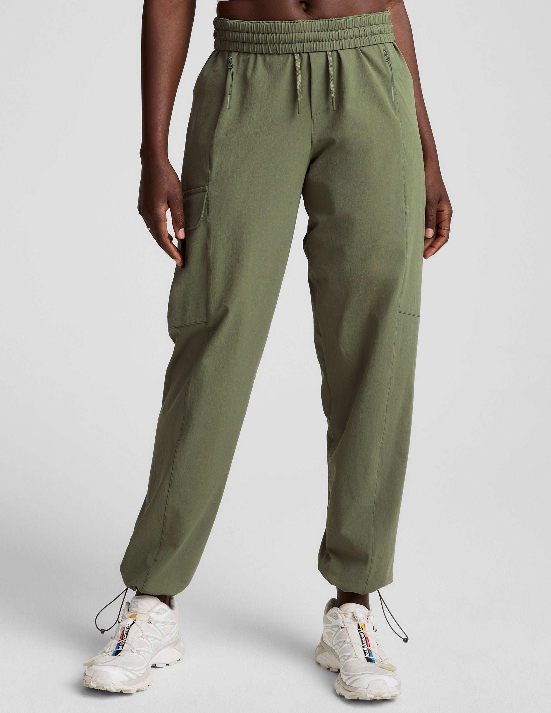 model wearing olive green cargo pants on a white background.