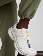 white sneaker with colorful accents worn by model in green cargo pants against a neutral background.