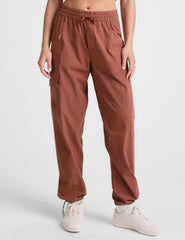 model wearing an orange ribbed tank top and orange cargo pants on a white background.